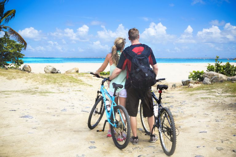 SM57 St. Maarten Mountain Bike Adventure, romantic, couple stop to take in the beach view in St. Maarten on a biking shore excursion on mountain bikes